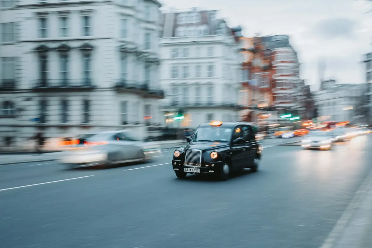 A black cab moving through a London street