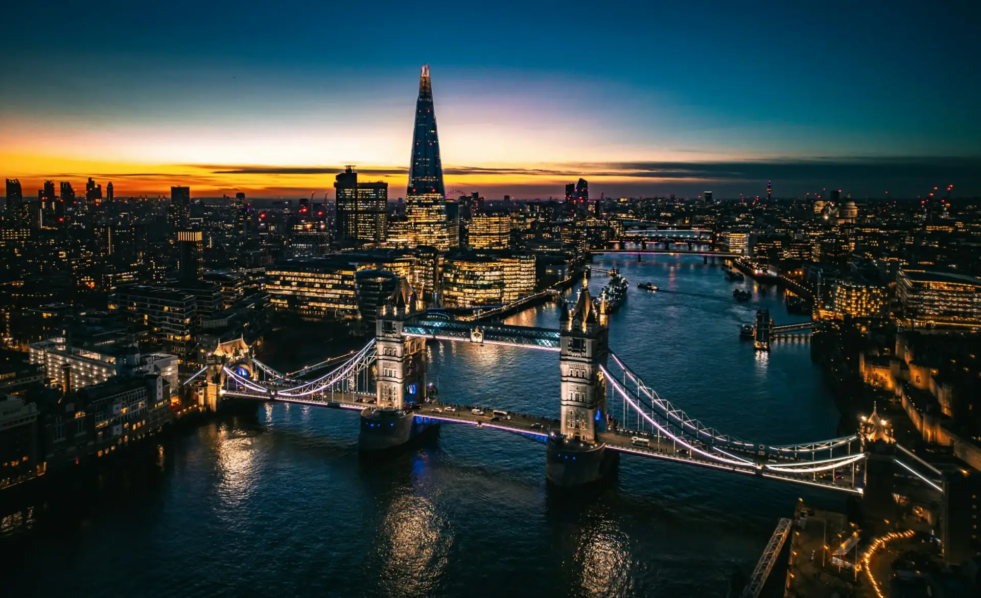 Tower Bridge and the Shard lit up along the Thames at dusk
