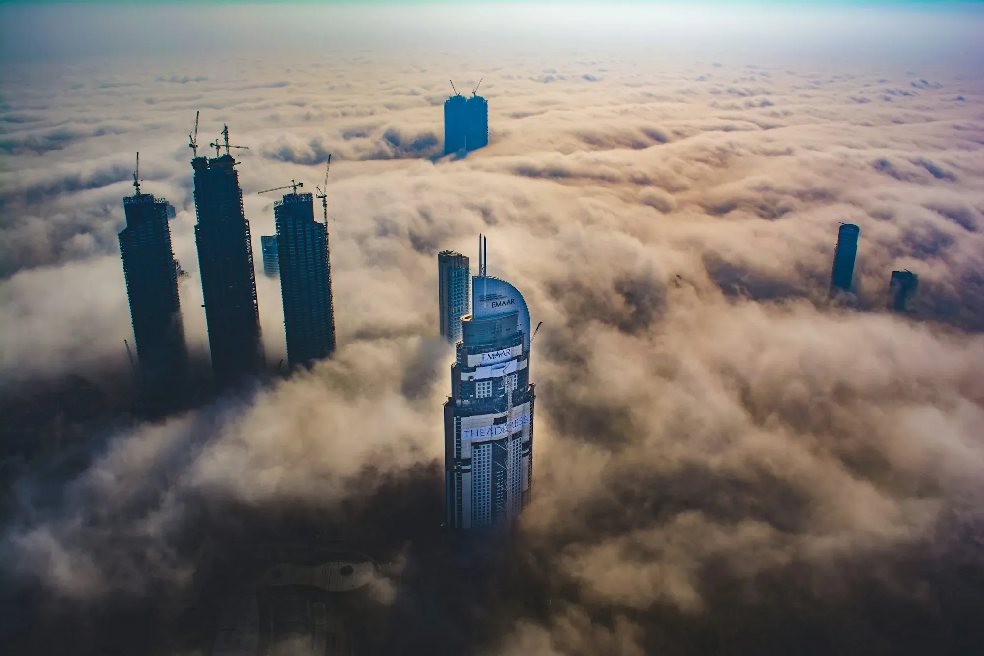 City towers rising through a deck of cloud