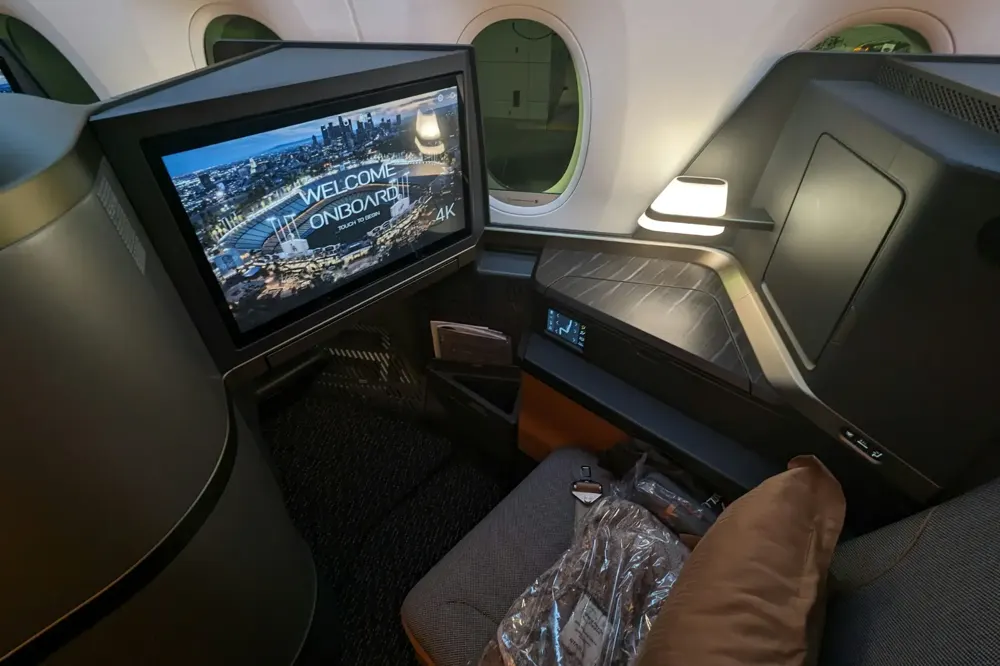 Business class suite with a door and a large screen