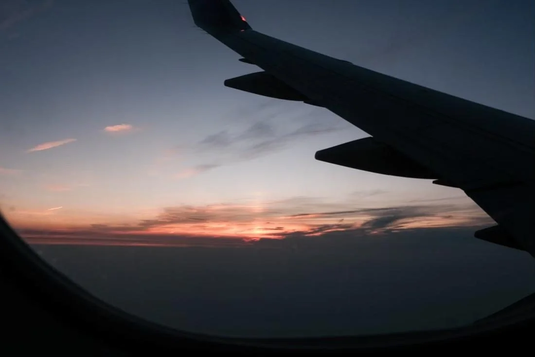 Wing at sunset above the clouds